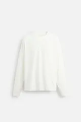 Camiseta color blanco hueso, de corte relaxed fit, cuello redondo y manga larga.