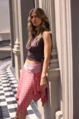 Falda midi color verde oscuro, con corte irregular y doblez en la cintura.