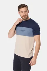 Remera de manga corta con diseño a bloques de color: azul marino en la parte superior, rosa viejo en el medio y gris claro en la parte inferior. Estampa con texto "Legacy Established Brand" en el pecho.