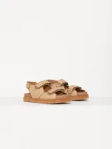 Sandalias bajas color beige con tiras de rafia y ajuste con velcro.