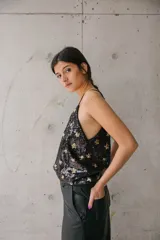 Musculosa negra con lentejuelas y estampado de estrellas doradas, con tirantes finos.