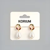 Aros colgantes dorados con forma de lágrima, con detalle de piedras rojas y verdes en la parte superior.