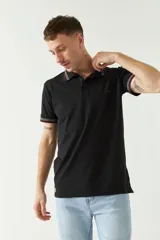 Chomba azul marino de manga corta con cuello polo y detalles de líneas grises en cuello y mangas. Tiene logo bordado en el pecho. Corte regular.