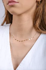 Collar dorado con cadena fina y dijes de ojitos turcos.