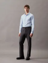 Camisa celeste de popelín de algodón elástico, corte slim, manga larga y cierre frontal con botones.