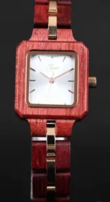 Reloj de pulsera con caja cuadrada y correa de eslabones de madera color borgoña. El dial es plateado con agujas y detalles dorados.