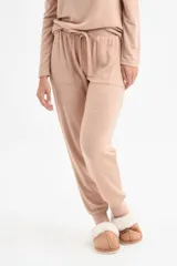 Pantalón de punto color beige, con cintura elástica y detalles de bolsillos.