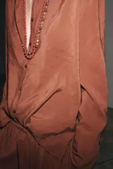 Camisa marrón de Zara Woman Collection confeccionada en hilatura con mezcla de lyocell. Tiene cuello redondo, manga larga acabada en puño, bajo asimétrico con aberturas laterales y cierre frontal con botones.