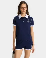Polo de piqué azul marino con cuello blanco, corte entallado y logo bordado en el pecho.