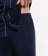 Conjunto de pijama corto azul marino con camisa de manga corta abotonada y short con cintura elástica. Presenta detalle de ribete contrastante en color blanco en el cuello, el frente de la camisa y el ruedo de las mangas.