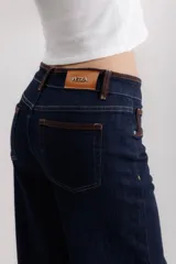 Pantalón de jean azul oscuro, de corte wide leg, con cintura alta y detalles de costuras en marrón.