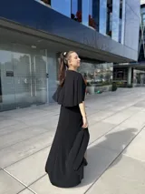 Vestido negro largo con escote en V, mangas cortas tipo kimono, falda cruzada con abertura y cinturón fino con strass.