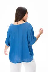 Blusa azul de corte holgado con mangas cortas arremangadas y escote redondo.