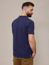 Chomba negra de piqué de algodón, corte clásico, con cuello y mangas acanalados y tapeta con dos botones blancos. Logo bordado en el pecho.