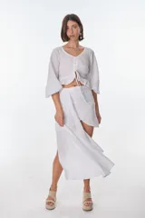 Conjunto de camisa celeste de mangas largas abullonadas y falda turquesa con detalle fruncido y lazo en el lateral.