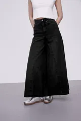 Pantalón jean negro de corte ancho y tiro medio.