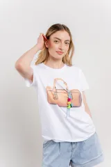 Remera blanca de algodón con estampado de un bolso con llavero colorido.