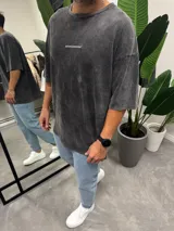 Remera gris oscuro con efecto lavado, corte holgado y mangas cortas. Estampado pequeño con la leyenda "BOHEMIANDESIGN" en el pecho.