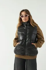 Chaleco puffer color crema con textura acolchada y bolsillos con cierre.