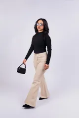 Pantalón Oxford color beige con corte ajustado en la cadera y acampanado desde la rodilla, con abertura en el ruedo.