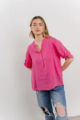 Camisa azul de lino con escote en V abotonado, bolsillo frontal y mangas 3/4 con trabilla.