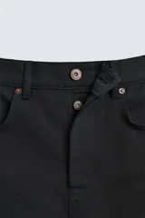 Pantalón de jean negro de corte recto, con cinco bolsillos y cierre frontal con botones. Colección especial Origins.