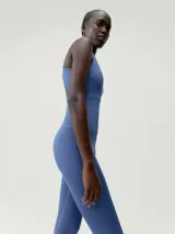 Mono largo de color azul, ajustado al cuerpo, con escote en V y tirantes anchos tipo halter. Presenta costuras visibles que definen la cintura y el busto.