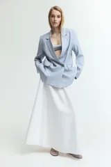 Blazer celeste de doble botonadura con solapas de muesca, hombreras y bolsillos delanteros ribeteados con solapa.