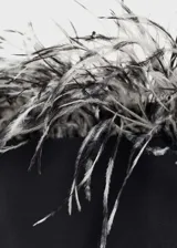 Vestido corto negro de fiesta, palabra de honor, con adorno de plumas en el escote y cierre lateral con cremallera.