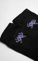 Medias negras con diseño de un monstruo de videojuego pixelado en color lila.