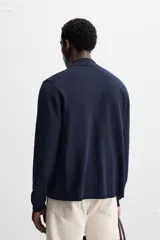 Camisa de punto azul marino, corte regular fit, tejida en hilatura con mezcla de lyocell. Cuello solapa, manga larga con acabados en rib y cierre frontal de botonadura.