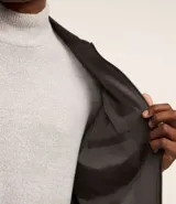Campera bomber de poliéster color gris oscuro, con cuello alto, cierre frontal con cremallera, bolsillos laterales, mangas largas con puños ajustados y bajo con ajuste elástico.
