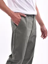 Pantalón de vestir azul oscuro, de corte recto, con bolsillos laterales y traseros. Se ajusta a la cintura con cinturón de cuero marrón.