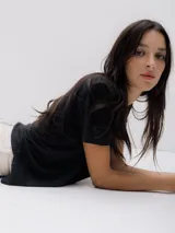 Remera negra de corte holgado, cuello redondo y mangas cortas.