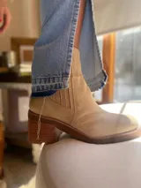 Botas de cuero color beige con elástico en los laterales, taco de madera y suela de goma.