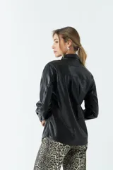 Sobrecamisa color beige de efecto cuero, con cuello clásico, cierre frontal con botones a tono, mangas largas con puños abotonados, dos bolsillos con solapa en el pecho y corte recto.