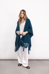 Ruana tejida en lana merino color amarillo pastel, con terminación de flecos.