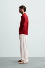 Sudadera color crema de corte recto, con cuello polo y cierre de cremallera metálica.