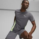 Remera deportiva gris de manga corta con paneles laterales verde flúor y logo de Puma estampado en el pecho.