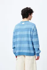 Sweater tejido en jacquard con diseño de franjas geométricas en tonos de azul.