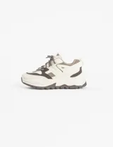 Zapatillas urbanas blancas con detalles en negro, cordones negros y suela chunky.