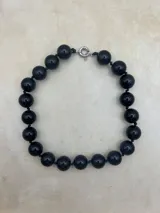 Collar de cuentas redondas de color negro y naranja alternadas.