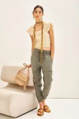 Pantalón babucha color verde militar, confeccionado en gabardina elastizada, con cintura y tobillos ajustados con elástico y cordón.