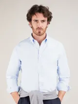 Camisa celeste de hombre, marca El Ganso, de corte regular fit, cuello button-down, manga larga con puño simple y logo bordado en el pecho. Confeccionada en tejido oxford compuesto por 93% algodón y 7% algodón reciclado.