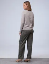 Polera de punto fino marca Nienty, color blanco, con cuello alto volcado y mangas largas con detalle de tajo en los puños.