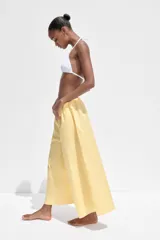 Pantalón culotte amarillo de tiro medio con cintura elástica y bolsillos laterales ocultos en la costura.