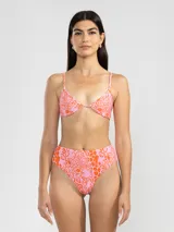 Conjunto de bikini con estampado animal print en tonos marrón y negro. El corpiño es de triángulo con tirantes finos y la bombacha es de tiro alto.