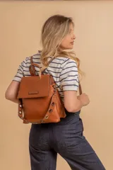 Mochila color verde oliva, tipo cartera, con tapa y doble cierre. Tiene dos compartimentos y división interna, además de un bolsillo trasero con cierre.