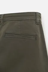 Pantalón cargo color verde oscuro, de corte relaxed fit, con bolsillos laterales con solapa y bolsillos traseros de vivo.