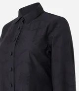 Vestido corto estilo camisa confeccionado en laise negro con bordado floral, cuello inglés, mangas largas abullonadas con puños elásticos y volado en el bajo. Cierre frontal con botones.